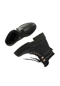 Zwarte leren enkellaarzen met nepbontvoering, roségouden oogjes en een plateauzool met uitgesneden accenten.