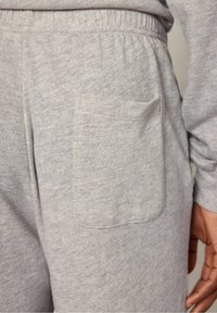 Sive trenirke z mehkimi vlakni, z elastičnim pasom in eno zadnjo žepom. Precej nevsiljiv meliran vzorec po celotni površini.