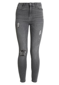 Jeans ajustados de talle alto en denim gris con detalles desgastados, que incluyen múltiples roturas y acentos deshilachados en las piernas.