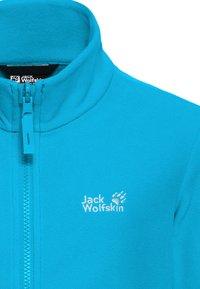 Φωτεινό μπλε φλις μπουφάν με εμπρόσθιο φερμουάρ και ψηλό γιακά, με λευκό λογότυπο Jack Wolfskin στο αριστερό στήθος.