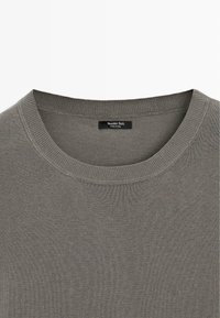 Pull à col rond en tissu tricoté gris avec un col côtelé et une petite étiquette de marque Massimo Dutti noire à l'intérieur de l'encolure.