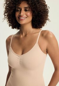 Beige camisole with thin straps, featuring a v-neckline and gathered detailing at the center, made from a soft, smooth fabric.