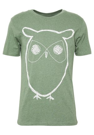Green short-sleeve t-shirt with a large white sketch-style owl face and body design on the front.