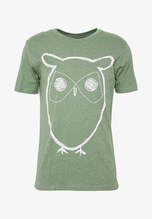 Green short-sleeve t-shirt with a large white sketch-style owl face and body design on the front.