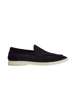 Mocassino slip-on in camoscio nero con suola bianca, tacco basso e dettagli cuciti lungo il bordo superiore.