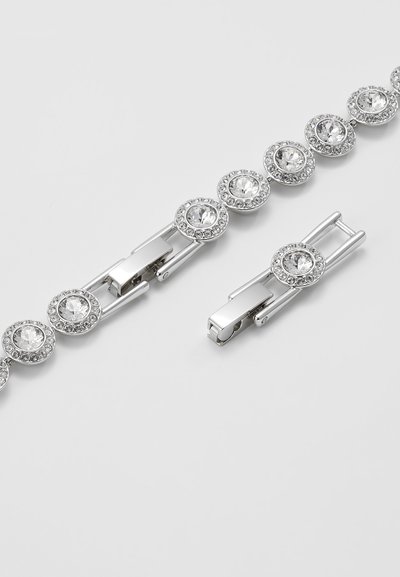Bracelet en argent avec des cristaux ronds et transparents entourés de petites pierres décoratives. Fermeture ajustable à une extrémité.