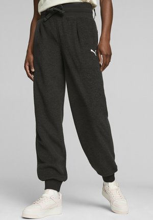 Pantaloni sportivi neri realizzati in tessuto morbido e testurizzato, con vita regolabile tramite cordino, polsi a coste e un logo bianco sulla coscia sinistra.