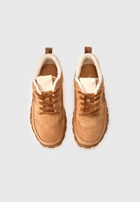 Μπεζ αθλητικά παπούτσια από κοτλέ με μαλακή επένδυση, στρογγυλή μύτη, υφή στο πάνω μέρος και ανθεκτική σόλα. Διαθέτουν καφέ κορδόνια και θηλιά στο πίσω μέρος για εύκολο φόρεμα.