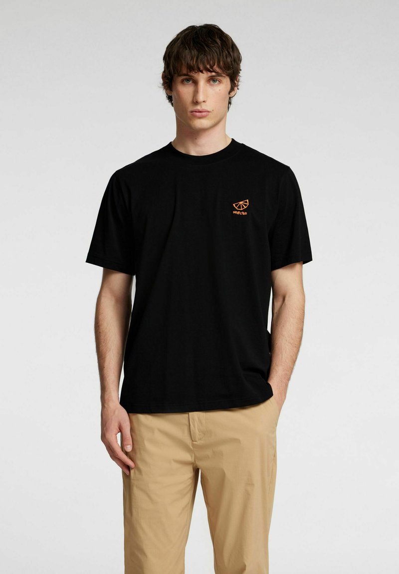 Svart bomullströja med en liten orange grafisk design på bröstet. Korta ärmar och rundad halsringning.