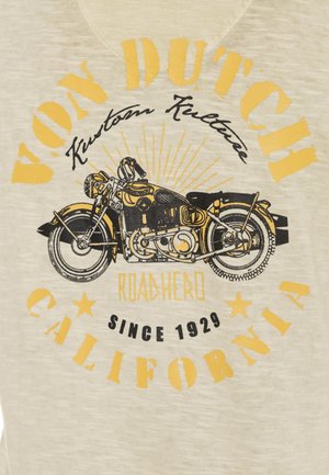T-shirt beige avec un graphisme de moto noir et jaune. Le texte indique "VON DUTCH," "ROADHERD," et "CALIFORNIA SINCE 1929." Texture douce.