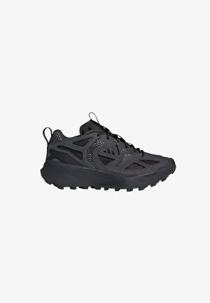 Zapatilla deportiva negra con parte superior de malla y material sintético, suela gruesa acolchada, banda de rodadura resistente y tiradores en el talón y la lengüeta.