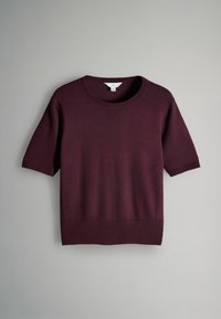Maglione a maniche corte di colore viola scuro, lavorato a maglia, con scollatura rotonda, polsini e orlo a coste, esposto in piano su sfondo grigio.