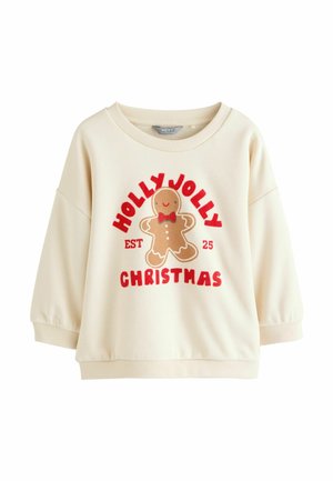 Vaaleanbeige collegepaita, jossa on pyöreä kaula-aukko, ja jonka etupuolella on piparkakkumieskuvio sekä punainen teksti "HOLLY JOLLY EST 25 CHRISTMAS." Pehmeää kangasta.