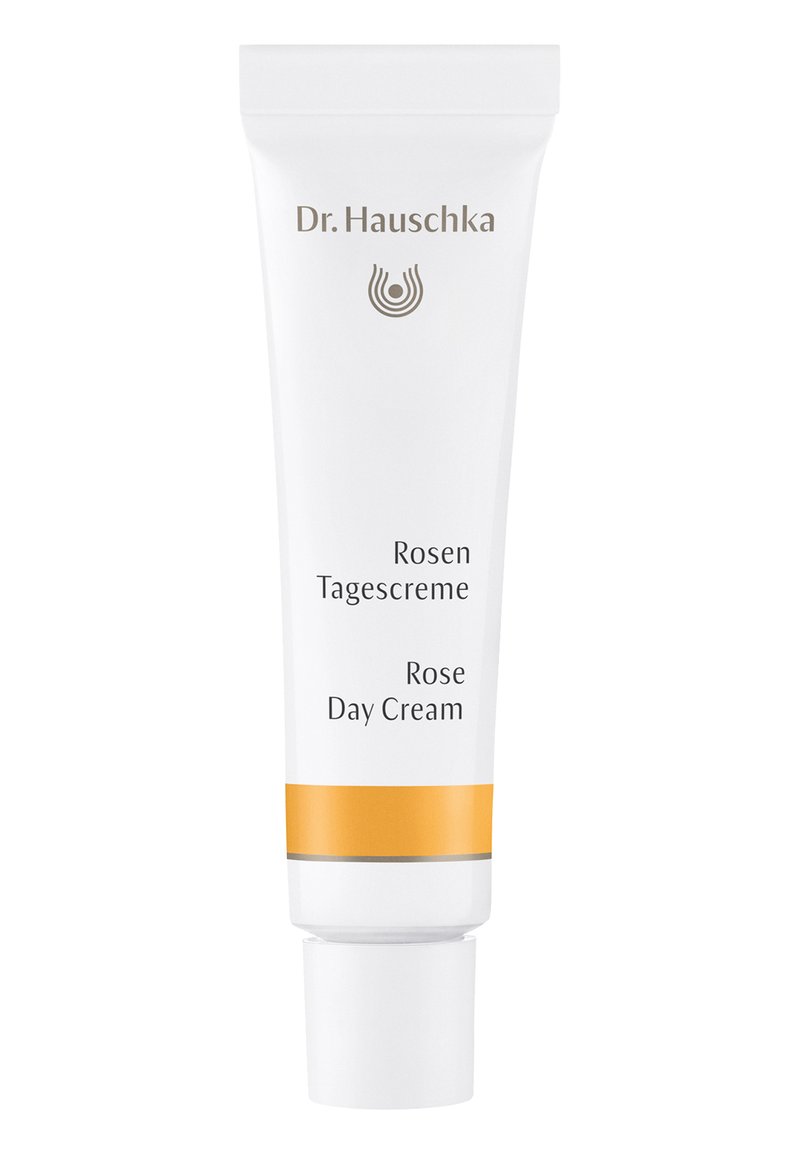 White tube of Dr. Hauschka Rose Day Cream, featuring gold and silver accents, text in black indicating product name and use.