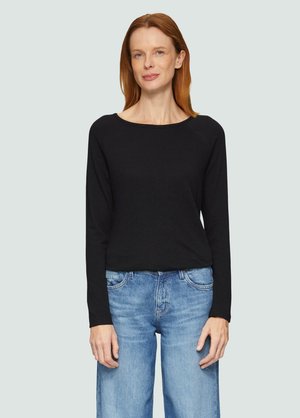 Zwarte long sleeve top met een ronde hals, gemaakt van zachte stof. Gepaard met lichtblauwe, high-waisted, wijde jeans.
