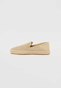 Espadrillas beige con tomaia perforata, design slip-on e suola in corda. Texture morbida, punta arrotondata e stile minimalista.