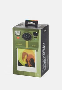 Green Polaroid Now+ camera box features a lens, buttons, and a photo of a portrait in warm tones, with a carry handle and filter set note.
