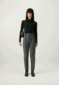 Juodas ilgomis rankovėmis marškinėliai, pilkos pritaikytos kelnes su aukštu liemeniu ir raukšlėmis, bei juodi auliniai bateliai; taip pat mažas juodas rankinukas.