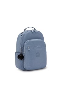 Modrý látkový batoh s přední kapsou na zip, boční kapsou, horní rukojetí a malým černým opičím klíčenkou připevněnou k němu.