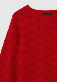 Maglione rosso lavorato a maglia con scollo rotondo, caratterizzato da un motivo testurizzato a zigzag e fili metallici sottili per un tocco di dettagli.