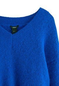 Modrý svetr s výstřihem do V, texturovaným pleteným materiálem a žebrovanými manžetami. Štítek uvádí "Lindex", velikost S, s měkkým a huňatým vzhledem.