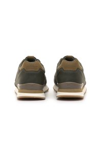 Scarpa da ginnastica verde scuro e marrone vista da dietro con logo embossato sul tallone e suole in gomma bianca-beige su sfondo bianco.