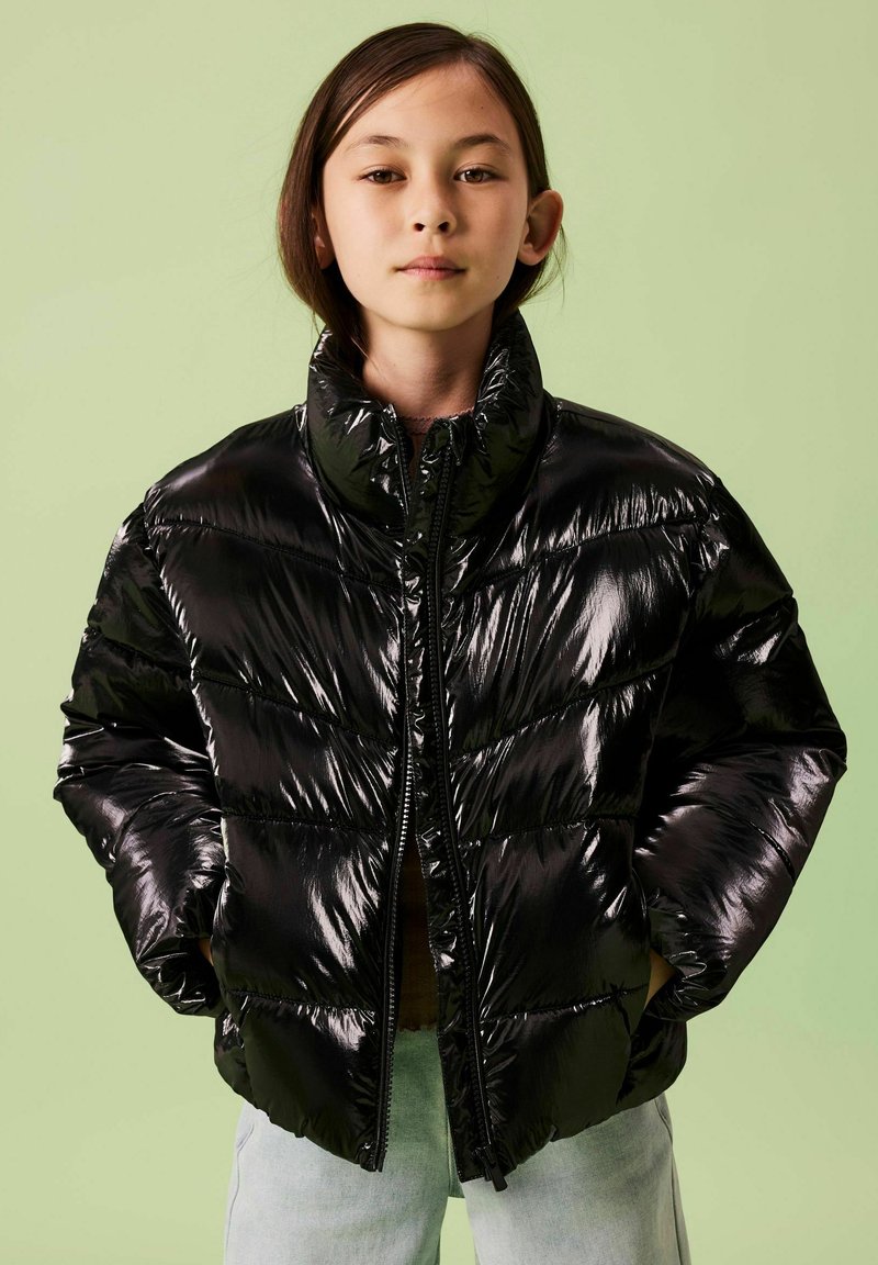 Giubbotto imbottito nero con finitura lucida, collo alto e chiusura con zip. Presenta sezioni a righe orizzontali e una vestibilità leggermente oversize.