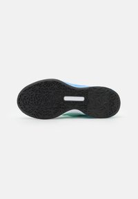 Shoe sole with black rubber, featuring a geometric pattern. Light blue and green accents visible on the side of the sole. Smooth texture.