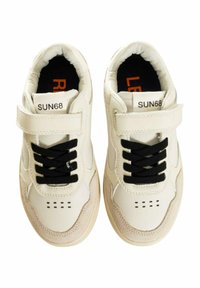 Scarpe sportive bianche con lacci neri, cinturino in Velcro e forature sulla punta. Materiale composto da una miscela di pelle e suede con una finitura testurizzata.