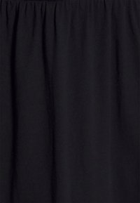 Svart tyg med en slät textur och samlad design upptill, med subtila draperingar, lämplig för olika klädesapplikationer.