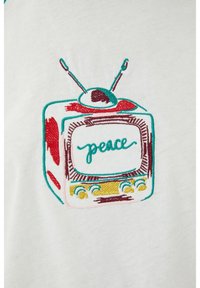 Bílá tkanina s barevným vyšívaným vzorem vintage televize se slovem "peace" v modrozelené a maroon barvě, doplněná žlutými knoflíky.