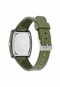 Montre en plastique vert avec un cadran carré, matériel en argent et un dos en acier inoxydable. Comprend un bracelet réglable avec plusieurs trous.