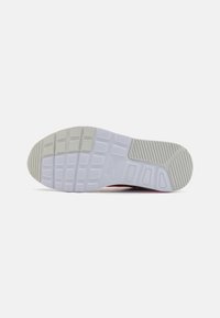 Semelle de chaussure Nike avec une base en caoutchouc blanc, texturée avec des motifs rectangulaires et linéaires, arborant un logo et un talon prononcé.
