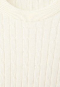 Pull tricoté couleur crème avec motif torsadé et encolure ronde côtelée, en gros plan.