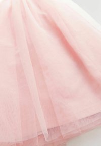 Tulle rose avec une texture douce et transparente, présentant des plis superposés et une apparence légère et aérienne. Le matériau est léger et délicat.