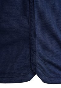 Marinblå nättyg med en texturerad mönstring, med synliga sömmar och en slitsdesign på sidan för ökad andningsförmåga och komfort.