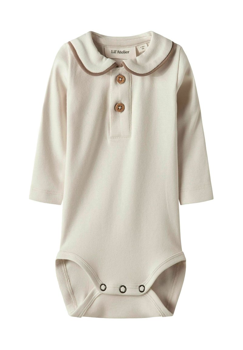 Biały bodysuit z długim rękawem i kołnierzykiem typu Peter Pan, zdobiony brązowym wykończeniem i dwoma drewnianymi guzikami. Trzy zapięcia na napy u dołu.