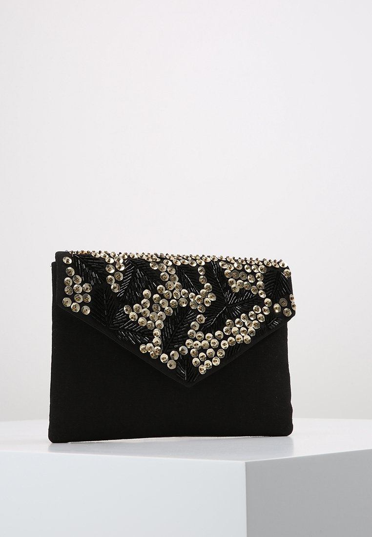 Pochette noire en forme d’enveloppe avec des clous ronds dorés et un travail de perles complexe formant des motifs géométriques sur le rabat.