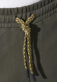 Olivgrüner Joggingbund mit gesammeltem Elastik, ausgestattet mit einem geflochtenen Kordelzug in Grau und Gelb, mit schwarzen Kunststoffenden.