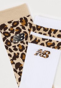 Leopardų raštai kojinės su tan ir rudos spalvos raštais, su baltomis kojinėmis, akcentuotomis tan juostele ir logo. Pagamintos iš minkštos medžiagos.