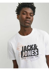 Camiseta blanca de algodón con un atrevido logotipo gráfico en negro "JACK & JONES" y diseños de contornos de mapa en púrpura y naranja. Manga corta, cuello redondo.