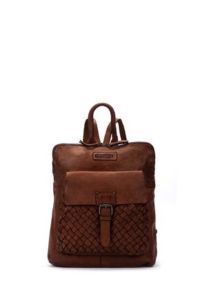 Sac à dos en cuir marron avec poche avant tissée, fermeture à boucle, double poignée supérieure et étiquette de marque Pikolinos visible.