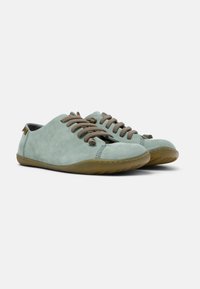 Scarpe in suede verde chiaro con lacci marroni, punta arrotondata e suola flessibile in gomma beige, con dettagli cuciti lungo le cuciture.