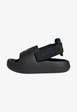 Chinelo preto com parte superior de borracha texturizada e tira de tecido ajustável. Design aberto na ponta com sola plana e texturizada e detalhe do logótipo.