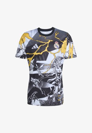Graphic t-shirt featuring black, white, and yellow colors. Design includes comic-style illustrations and the Real Madrid logo on the chest.