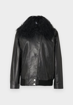 Musta nahkatakki, jossa kihara musta turkishalkio, resorireunukset hihoissa ja helmassa, vinottain kulkeva vetoketjusuljenta ja sivutasku. Sileä pinta.