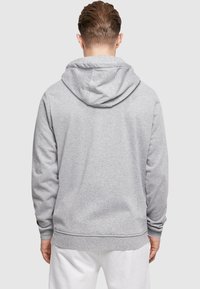 Gray cotton hoodie featuring a simple design, a drawstring hood, and ribbed cuffs and hem. The back is smooth with no visible logos.