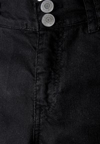 Jean en denim noir avec un devant plat, comprenant deux boutons en métal argenté et des détails de couture visibles sur la fermeture éclair et les coutures latérales.