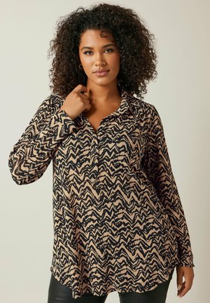 Camicia a maniche lunghe beige con un motivo a zigzag nero. Presenta un colletto e una vestibilità morbida, realizzata in un materiale morbido e testurizzato.