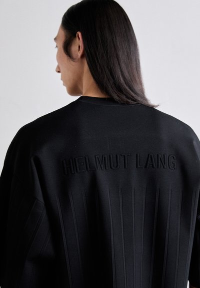 Czarna bluza z poziomymi fałdami i wytłoczonym napisem "HELMUT LANG" z tyłu. Materiał wydaje się gładki i strukturalny.